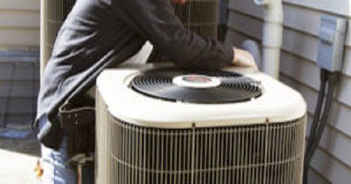 A technician performing maintenance on an outdoor HVAC condenser unit for Blanton & Son Heating and Cooling in Clayton, NC