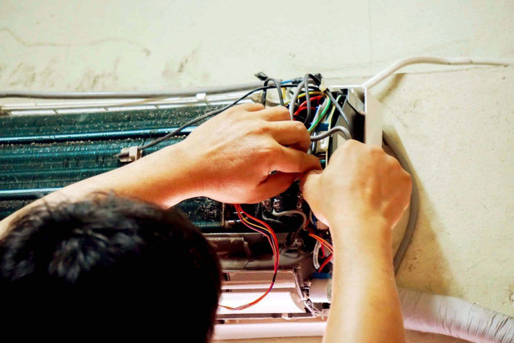 A technician servicing the internal components of an indoor AC unit for AC Phoenix LLC AC Repair & Service in Glendale, AZ.