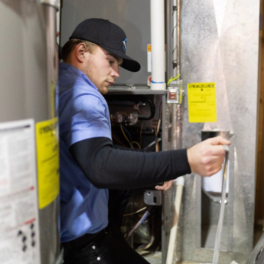 An APEX Clean Air technician servicing an indoor furnace or air handler unit in South Salt Lake, UT.