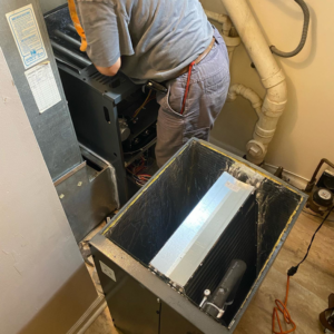 A technician servicing an indoor HVAC unit and air handler for Doctor Air HVAC in Philadelphia, PA.