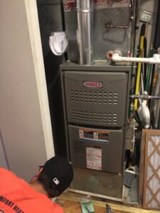 A technician servicing a Lennox furnace, performing HVAC work for Around The Town Heating and Cooling in Chicago, IL.