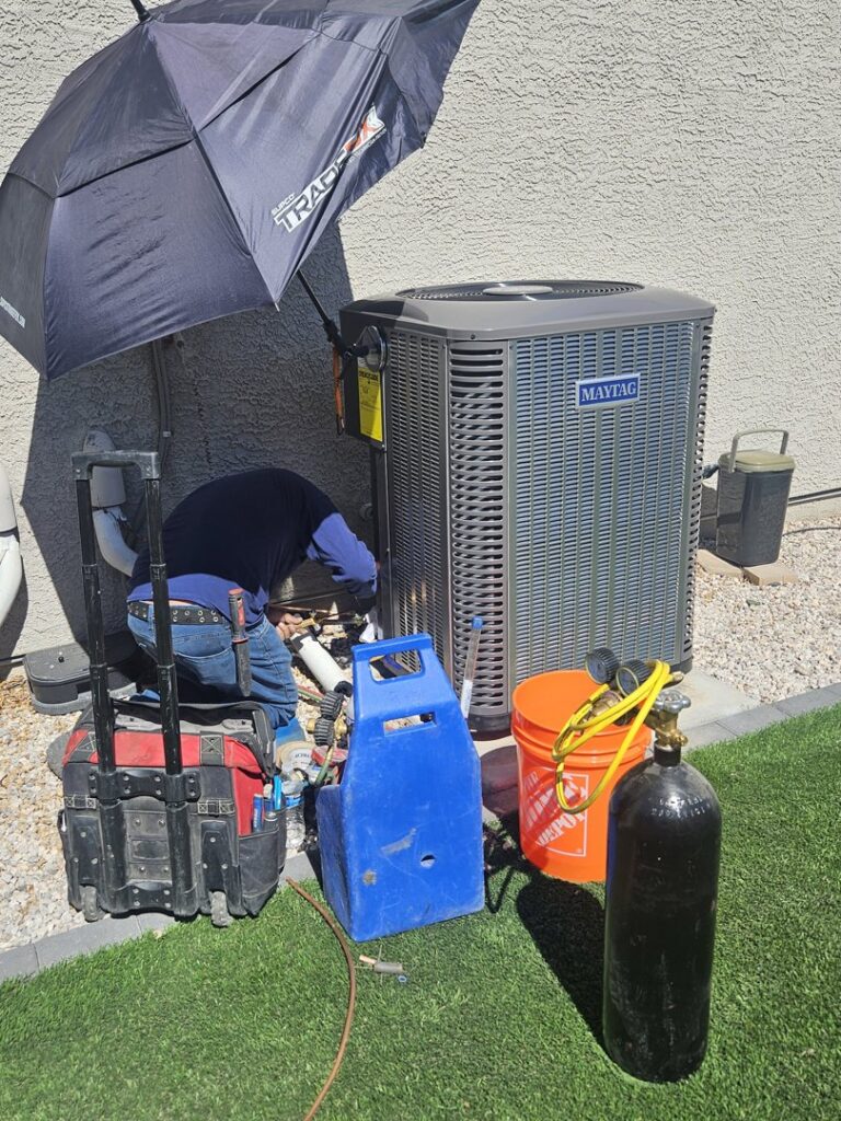 A technician servicing an outdoor Maytag HVAC unit with tools and equipment for Colton Air Conditioning - Las Vegas in Las Vegas, NV.