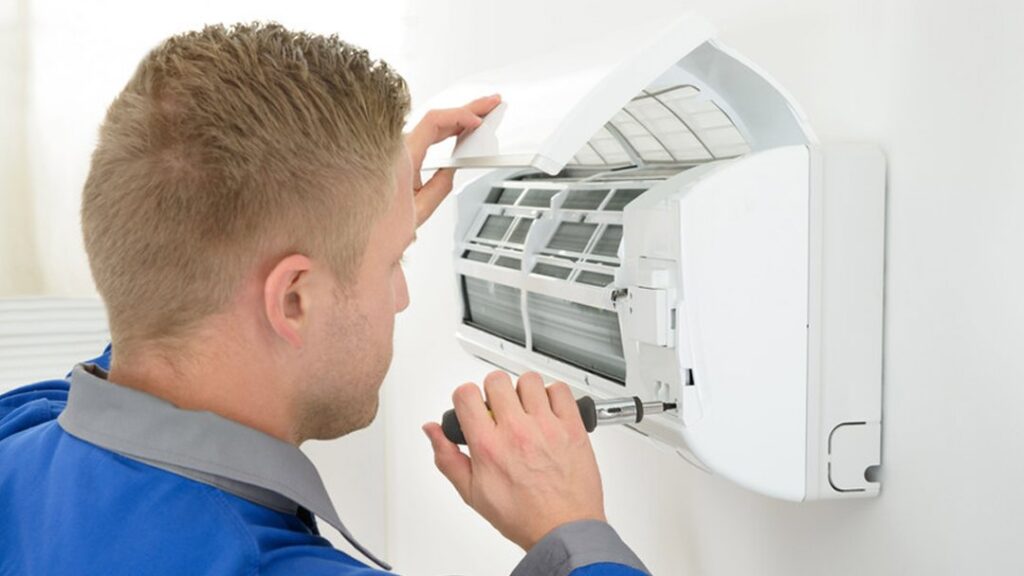 A technician servicing a mini-split air conditioning unit for Pugh Heating & Air Conditioning in Holland, OH.