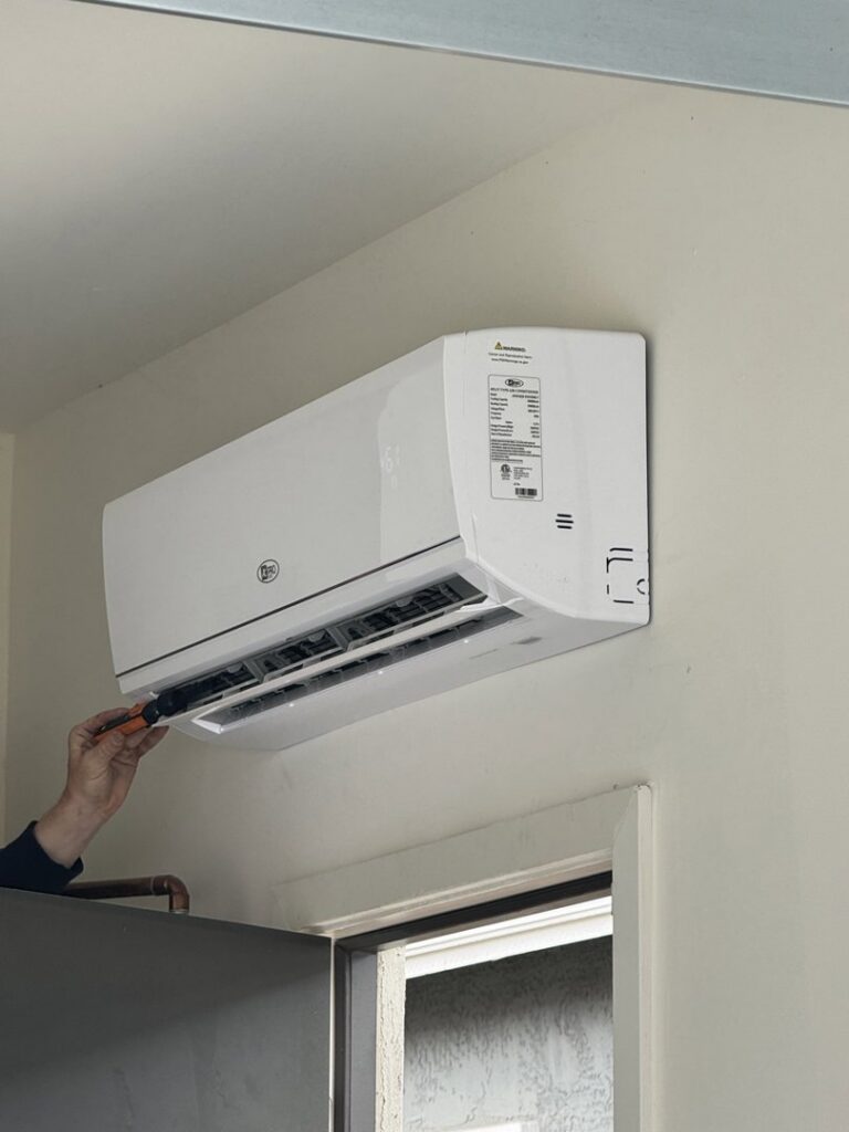 A technician servicing an indoor mini-split HVAC unit, demonstrating expertise from Blue Collar Mechanical LLC in Indianapolis, IN.