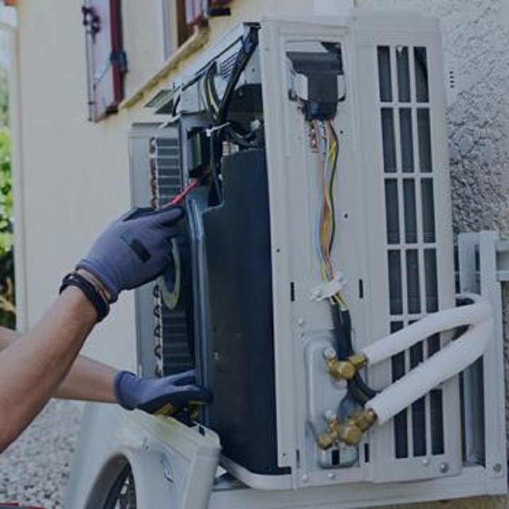 A technician servicing an outdoor mini-split or heat pump unit for Mid-City HVAC, INC. in Chicago, IL.