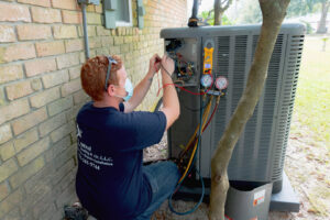 A technician servicing an outdoor AC unit for Air Control Heating & Air in Central City, LA