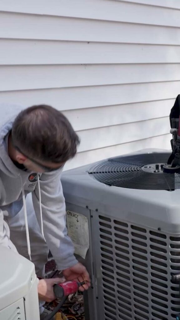 An Infinite Comfort technician servicing an outdoor AC unit in Youngsville, NC.
