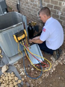 A technician servicing an outdoor air conditioning unit for Pipe Wrench Plumbing, Heating & Cooling, Inc in Knoxville, TN.