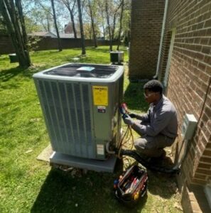 A technician servicing an outdoor AC unit with gauges for RESTQ HVAC Repairs & Services in Rockville, MD.