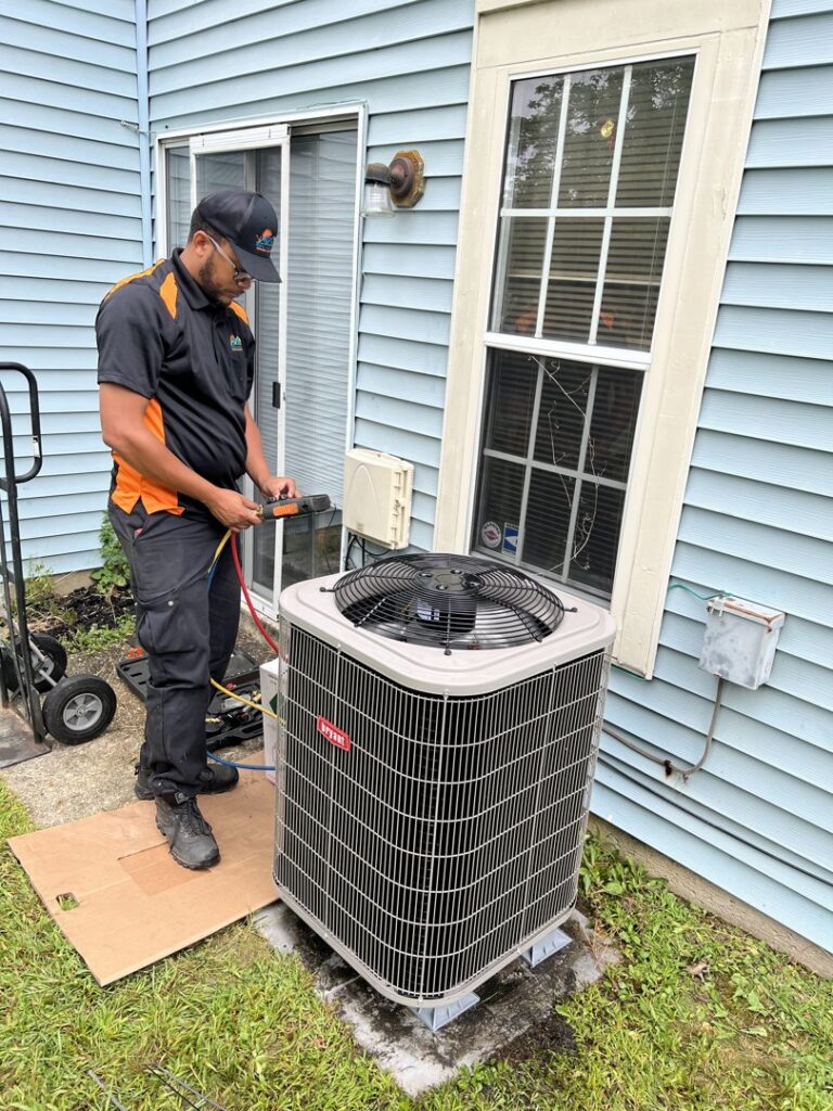 A technician servicing an outdoor AC unit, connecting gauges for diagnostic work by Simply Home Service in Gaithersburg, MD.