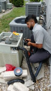 A technician servicing an outdoor AC unit for Southwest Florida Air Quality in Cape Coral, FL