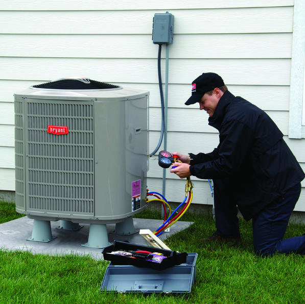 A technician servicing an outdoor air conditioning unit with gauges at a job site by Supreme Stands in Maple Grove, MN