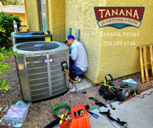 A technician from Tanana Air Conditioning & Heating servicing an outdoor AC unit with tools on the ground in Las Vegas, NV.