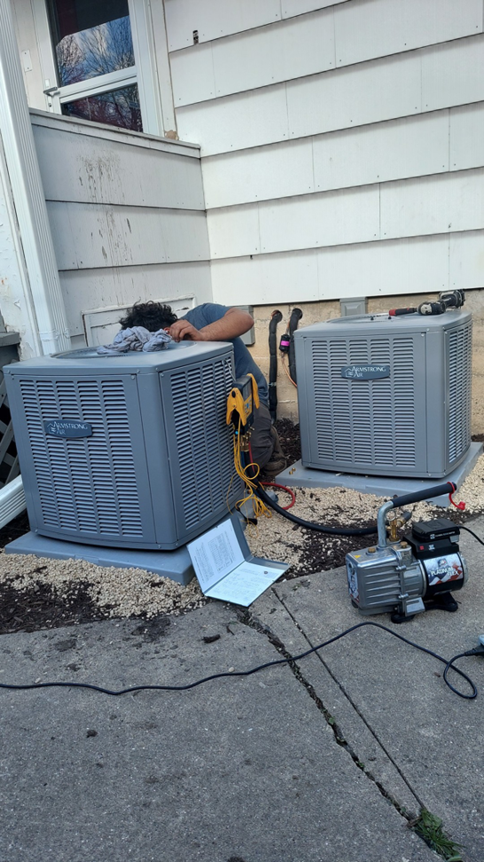 A technician servicing an outdoor air conditioning condenser unit for WC Heating & Cooling Corp. in West Chicago, IL.