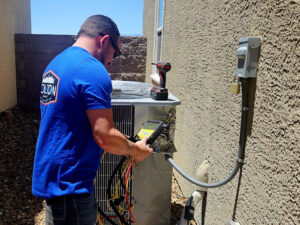 A technician servicing an outdoor HVAC unit with diagnostic tools for Colton Air Conditioning - Las Vegas in Las Vegas, NV.