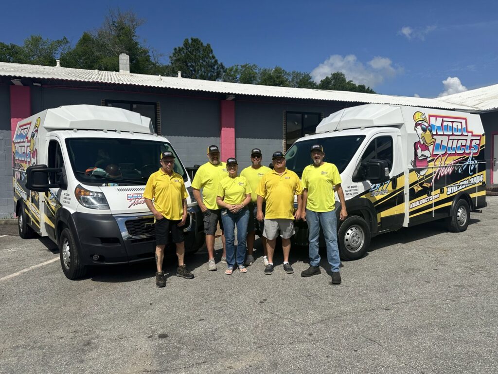 An HVAC technician from Kool Ducts Heat & Air servicing an outdoor air conditioning unit in Wilmington, NC.