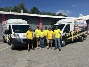 An HVAC technician from Kool Ducts Heat & Air servicing an outdoor air conditioning unit in Wilmington, NC.