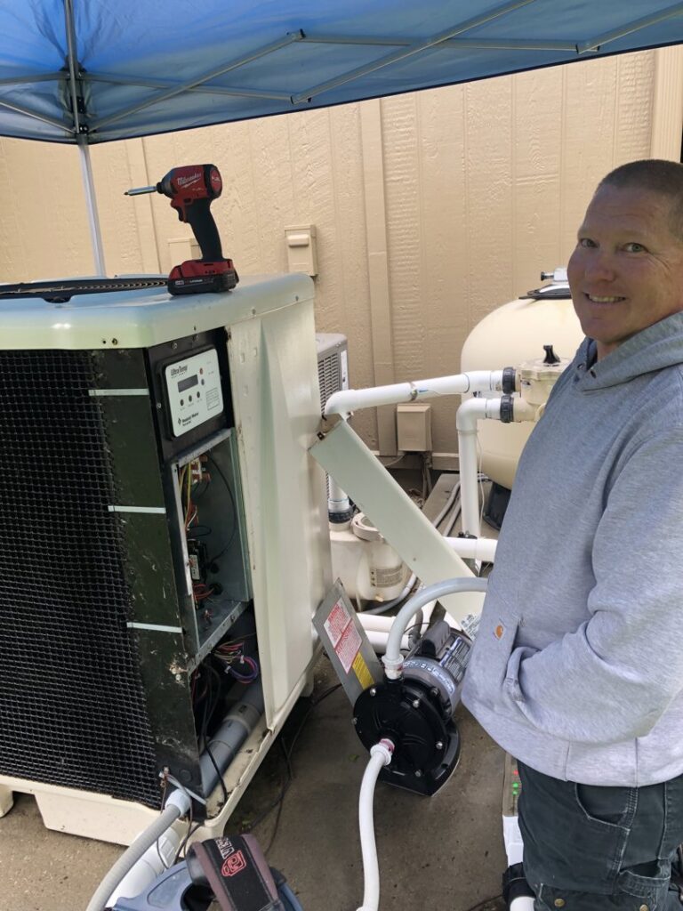 A Pro-Cool Air Conditioning & Heating technician servicing a pool heater system in Blue Springs, MO.