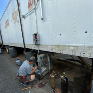 A technician servicing a refrigeration unit on a commercial trailer for Doctor Air HVAC in Philadelphia, PA.