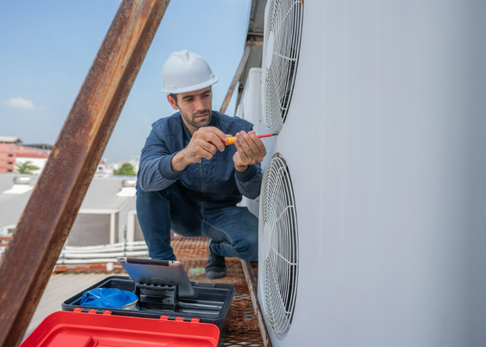 A technician servicing a rooftop air conditioning unit for Greater Boston Heating & Air in Boston, MA.
