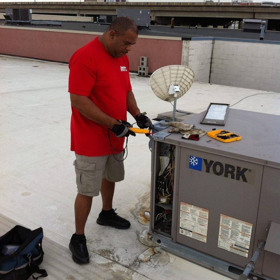 A Daniels HVAC technician servicing a commercial rooftop AC unit in Philadelphia, PA.