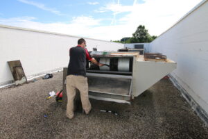 A technician servicing a large commercial rooftop HVAC unit for Air Care & Restoration Co. in Bethlehem, PA.
