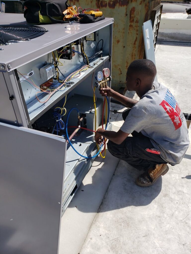 A technician from Booker Heating & Air servicing a commercial rooftop HVAC unit in Richmond, VA.