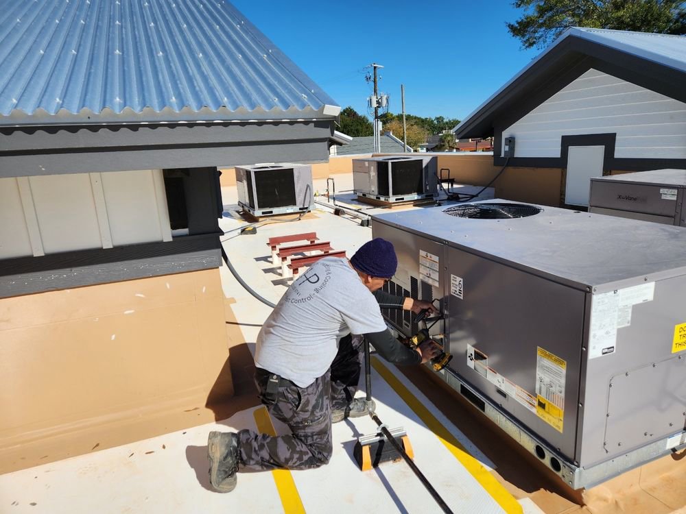 An HVAC technician servicing a commercial rooftop heating and cooling unit for HP Mechanical LLC in Santa Rosa, CA.