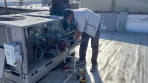A technician servicing a large rooftop HVAC unit with tools, performed by Modern HVAC Technology in Chicago, IL.