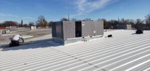 A Tornado Heating and Air technician servicing a commercial rooftop HVAC unit in Tulsa, OK.