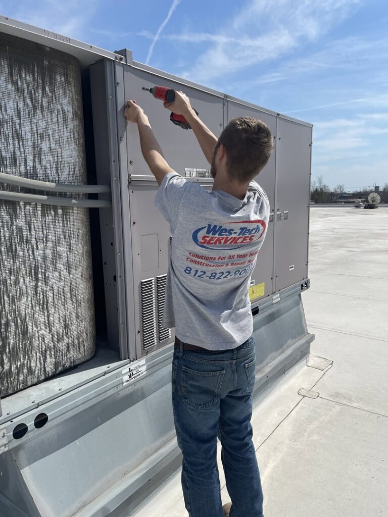 A Wes-Tech Services technician servicing a commercial rooftop HVAC unit in Bloomington, IN.