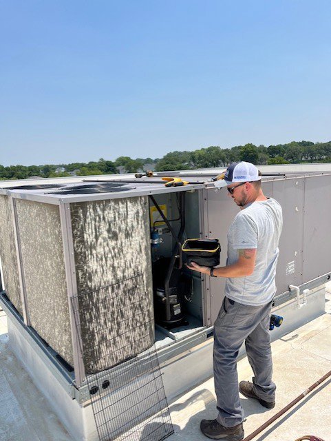 An HVAC technician servicing a commercial rooftop unit for Marie Keding Bryant Iowa Heating and Cooling in Ankeny, IA.