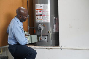 A Service Experts Phoenix technician servicing a water heater in a residential garage in Phoenix, AZ.