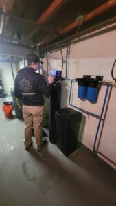A T. D'Albora Heating and Cooling technician servicing a water treatment system in Erie, PA.