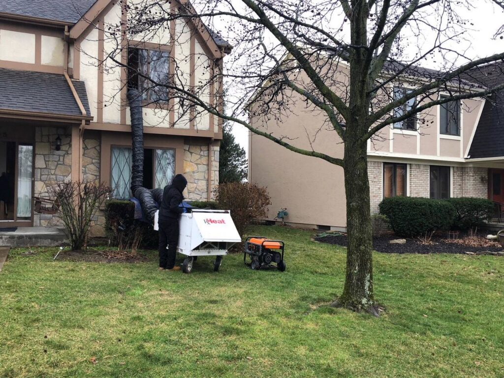 A technician setting up a bed bug heat treatment machine outside a residential home for Protective Thermal Solutions in Columbus, OH.