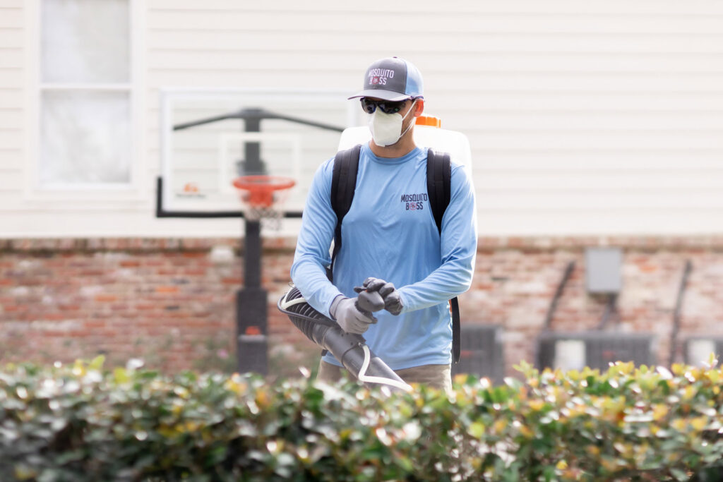 A Mosquito Boss technician spraying a residential backyard for pest control in Brandon, MS