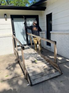 An Elite Pest Control technician spraying a doorway and exterior area for pests in Maple Grove, MN.