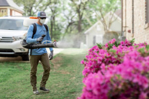 A Mosquito Boss technician spraying flowering bushes for pest control in Brandon, MS