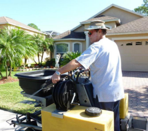 A technician spraying for pest control around a residential home by Allstate Termite and Pest Control Inc. in Tampa, FL.