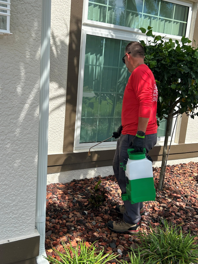 A Paske Pest Control & Wildlife Solutions technician spraying the foundation of a house for pest control in Cape Coral, FL.