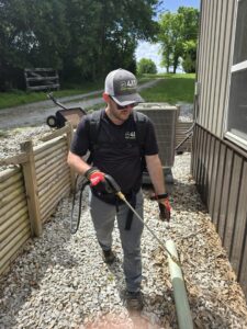 A pest control technician from Titan Pest Pro - Springfield spraying the foundation of a house in Springfield, MO.