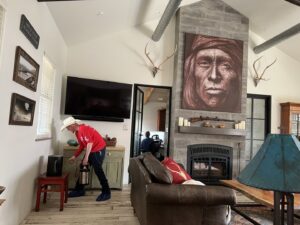 A Blessed Pest Control technician performing an indoor pest treatment in a living room in San Antonio, TX