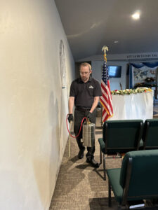 A technician from Eagle Eye Extermination spraying an indoor wall for pest control in Kalispell, MT.