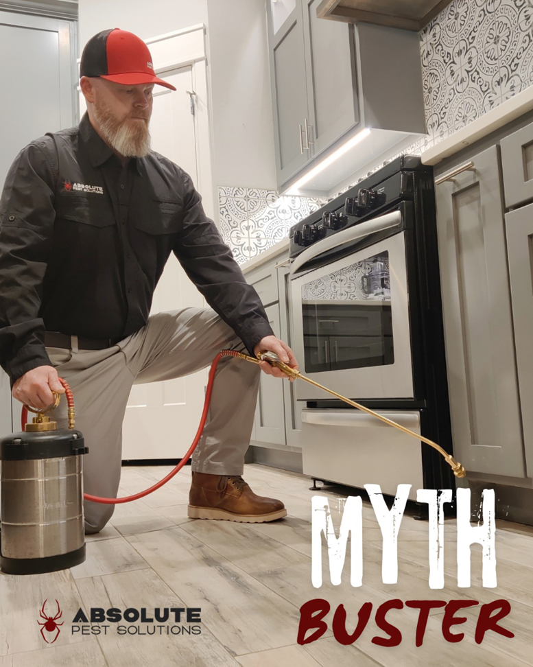 An Absolute Pest Solutions technician applying pest control treatment in a kitchen in Piedmont, OK.