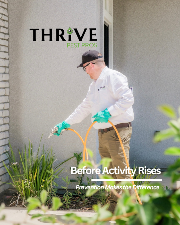 A Thrive Pest Pros technician spraying pest control solution around the foundation of a home in Clovis, CA.