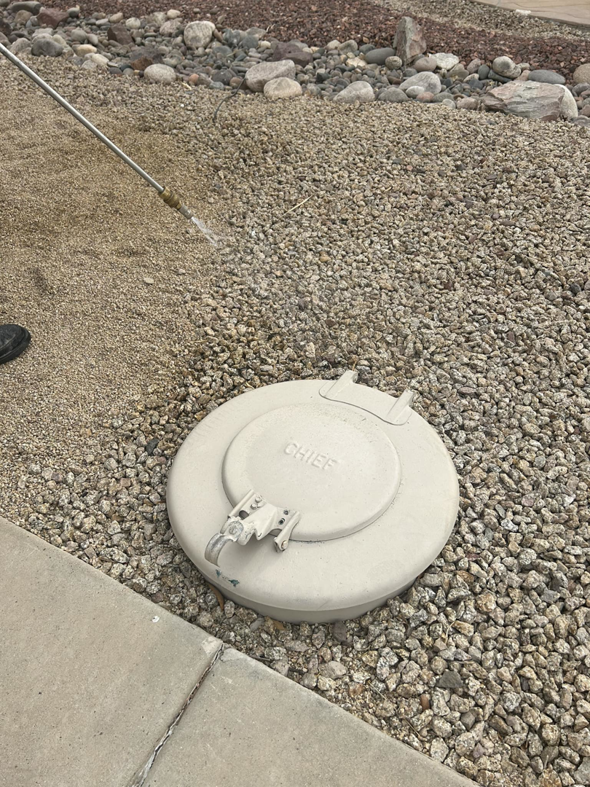 A technician from Preferred Choice Pest Control applying pest treatment to the ground in Surprise, AZ.