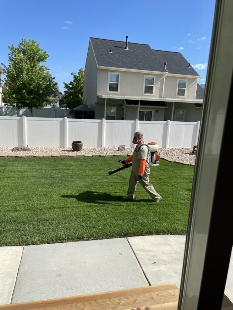 A Mosquito Hunters of Layton-Kaysville-Farmington technician spraying a residential yard for pest control in Layton, UT.