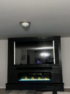 A technician from A-1 Carolina Chimney Masters sweeping a residential chimney on a roof in Fayetteville, NC