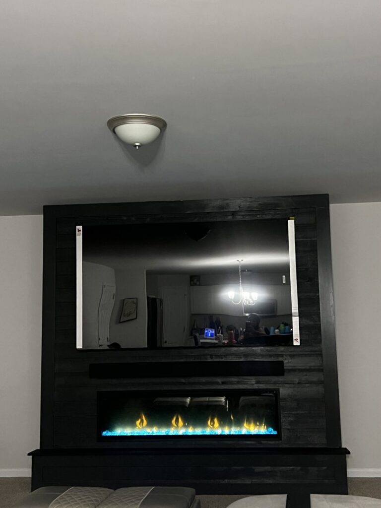 A technician from A-1 Carolina Chimney Masters sweeping a residential chimney on a roof in Fayetteville, NC