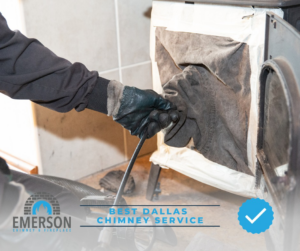 A technician performing a chimney sweep and cleaning inside a fireplace at Emerson Chimney & Fireplace in Dallas, TX.
